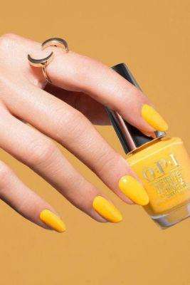 Bright yellow nails add a pop of color to a navy blue dress