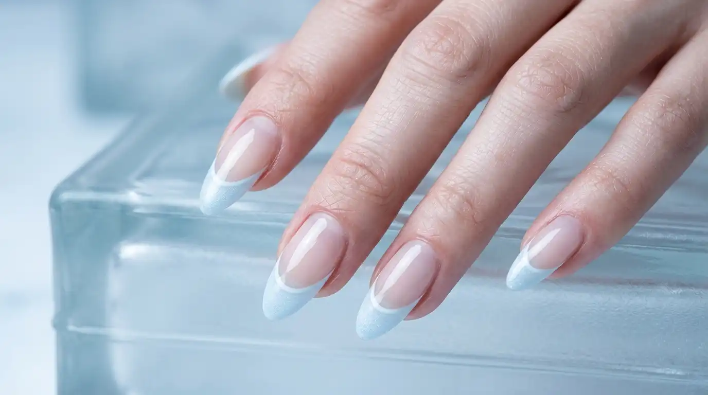 Nails with a pale icy blue frosted tip over a clear base