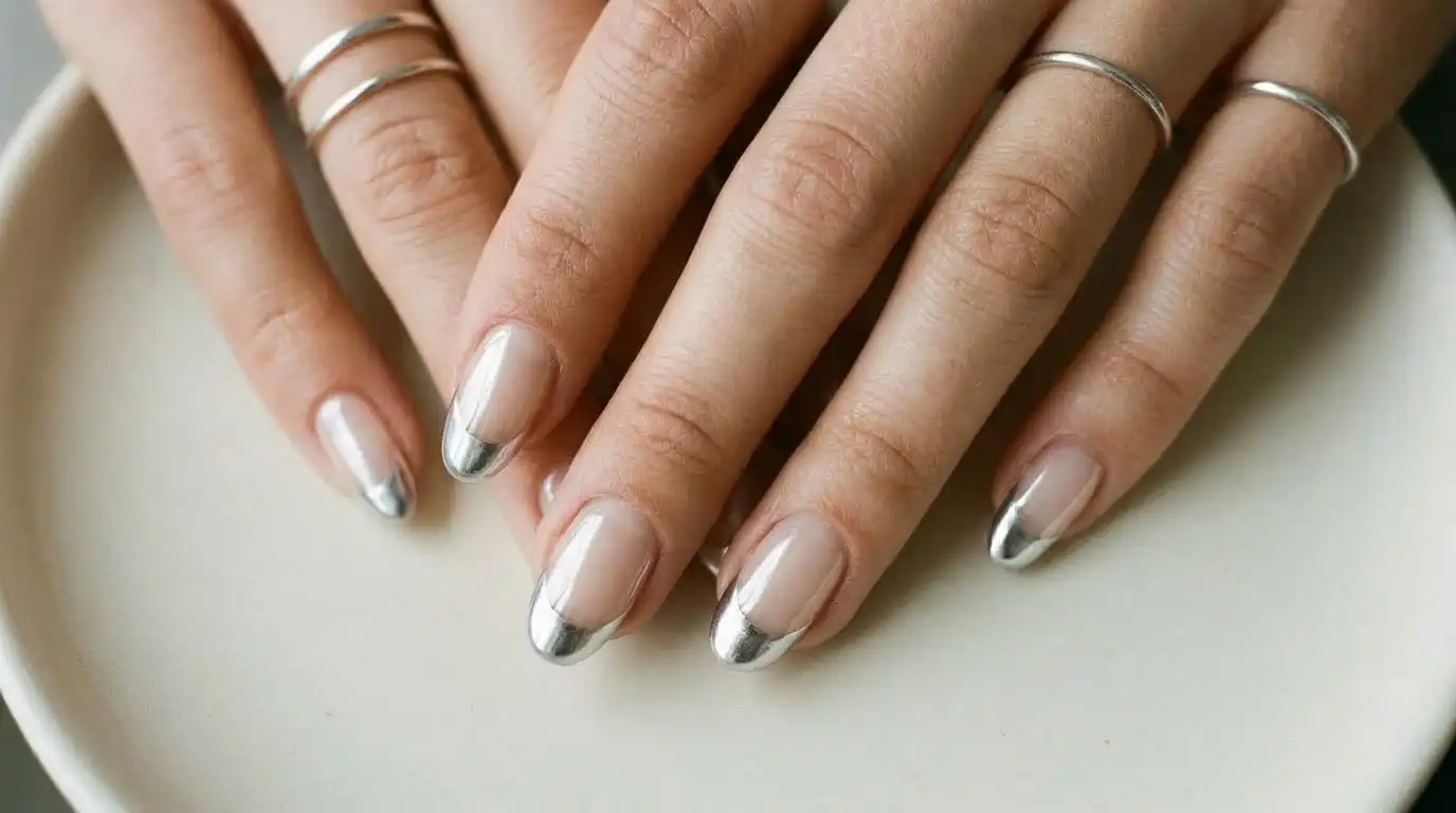 Nude base nails with metallic chrome silver frosted french tips